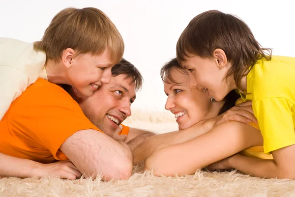 Szczęśliwa rodzina na dywanie — Zdjęcie stockowe