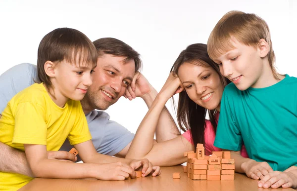 Família feliz brincando à mesa — Fotografia de Stock
