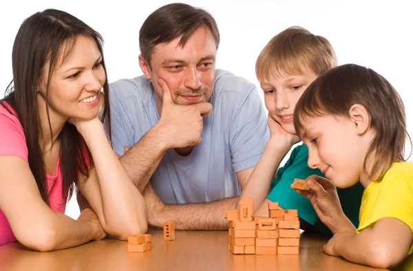 Família feliz brincando à mesa — Fotografia de Stock