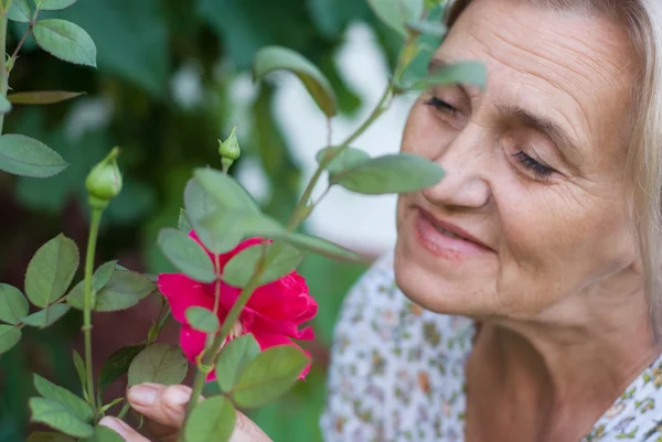 Aged woman with flower — Stock Photo, Image