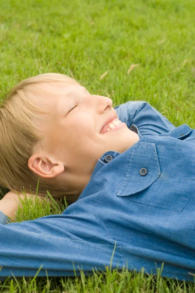 Chłopak leżał na trawie — Zdjęcie stockowe