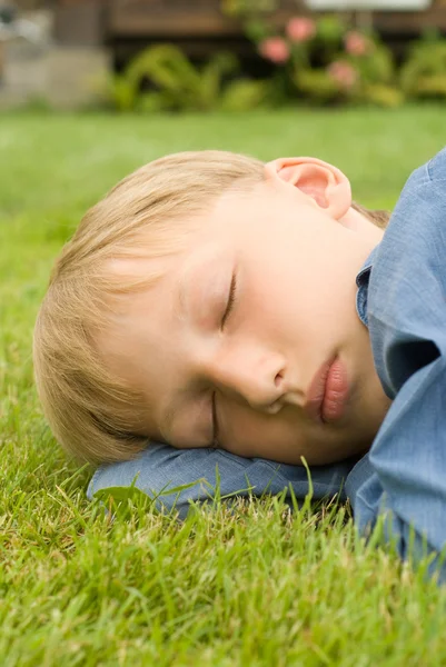 Мальчик спит на траве — стоковое фото