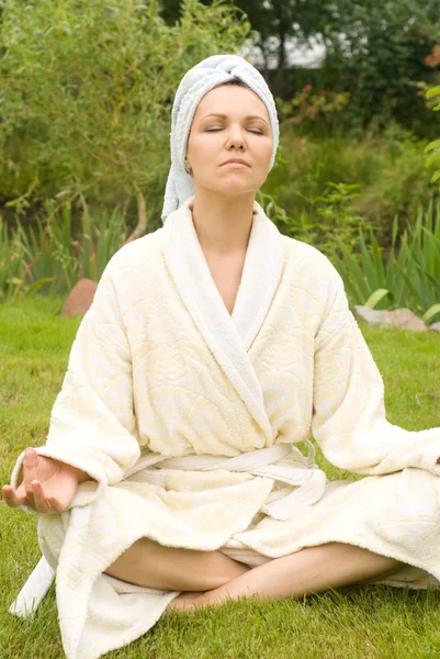 Женщина в халате медитирует — стоковое фото