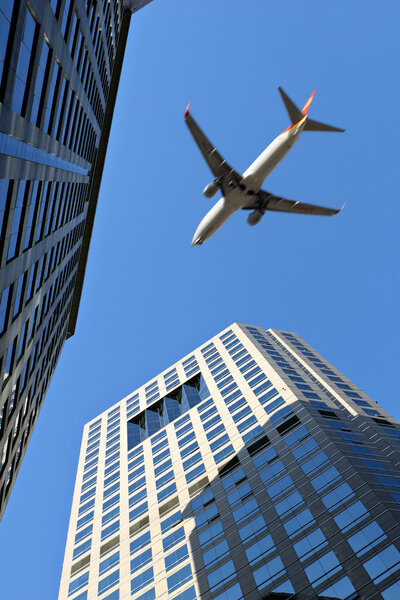 Airplane flying over the top of modern buildings, beijing, china.