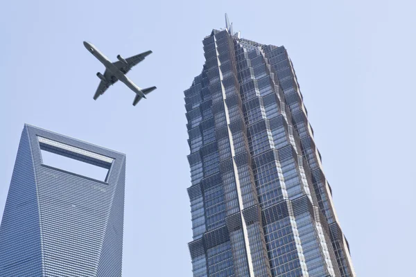 stock image Shanghai: plane over modern buildings