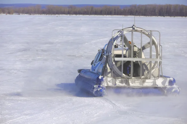 Hovercraft traversant une rivière gelée contre un ciel bleu — Photo