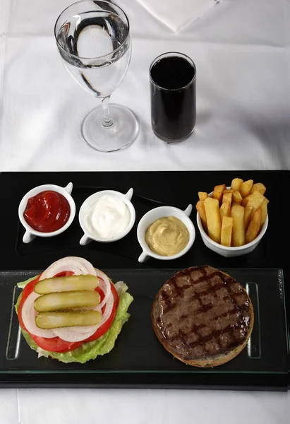 Hamburger en Franse frietjes geserveerd op een klassieke tafel — Stockfoto