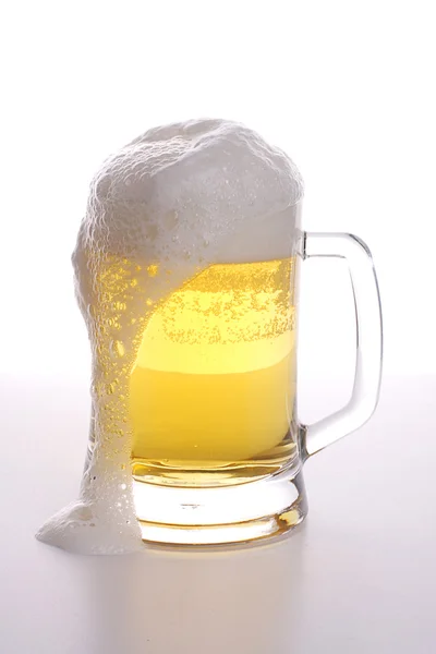 Caneca de cerveja com espuma sobre fundo branco — Fotografia de Stock