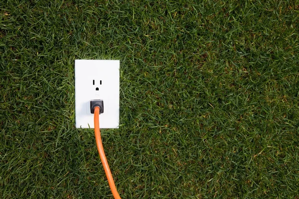 Toma eléctrica en hierba —  Fotos de Stock