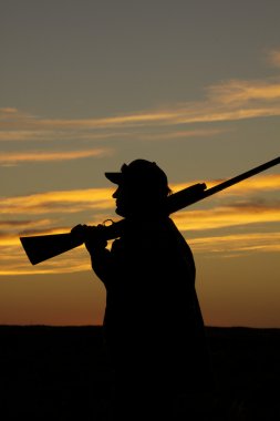gün batımı, av tüfeğiyle avcı