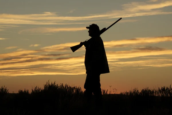 Jager met shotgun in de zonsondergang — Stockfoto