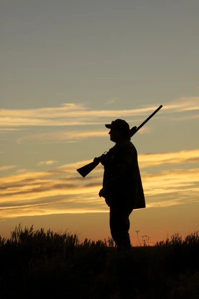 Chasseur avec fusil de chasse au coucher du soleil — Photo