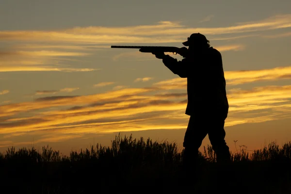Jäger mit Schrotflinte im Sonnenuntergang — Stockfoto