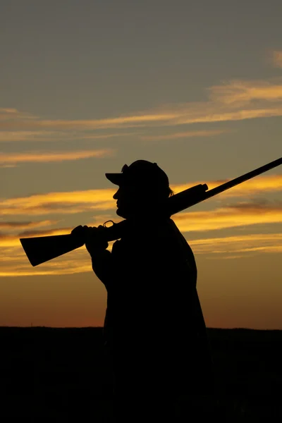 Chasseur avec fusil de chasse au coucher du soleil — Photo