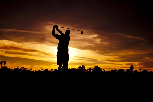 석양에 골프를 치는 사람 — 스톡 사진