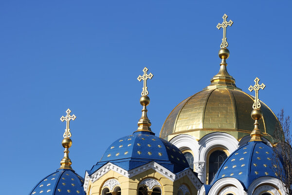 Купола христианской церкви с крестами на фоне яркого голубого неба