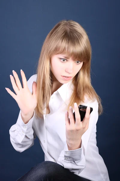 The young girl looks at phone with surprise — Stock Photo, Image