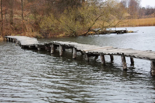 Деревянный мост через реку осенью — стоковое фото