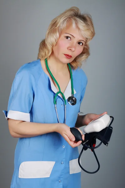 Die Ärztin hält das Gerät zur Druckmessung in der Hand — Stockfoto