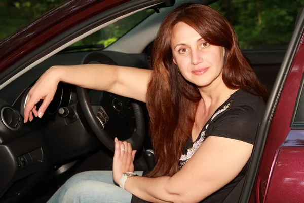 Žena průměrné let řídí auto — Stock fotografie