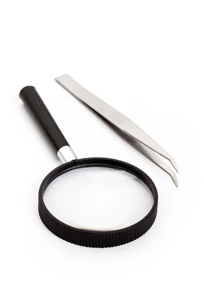 Tweezers and magnifying glass — Stock Photo, Image