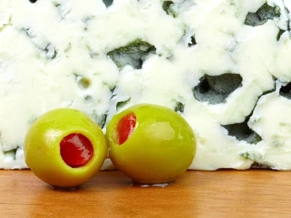 Close-up of green olives and blue cheese. — Stock Photo, Image