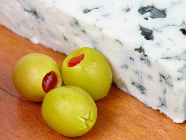 Крупный план зеленых оливок и голубого сыра . — стоковое фото