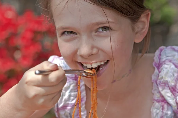Chica está comiendo espaguetis —  Fotos de Stock