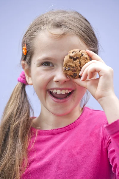 Girl eating chocolate cookies — Stock Photo, Image