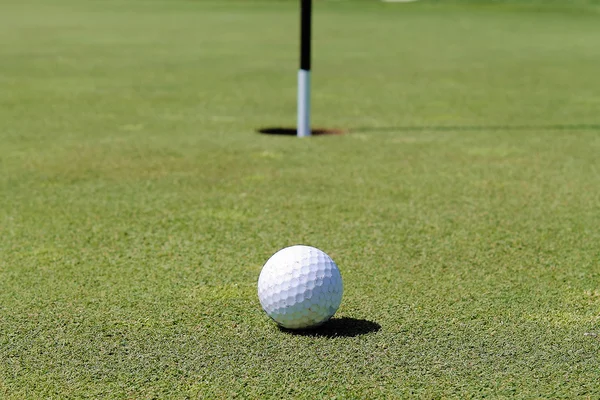 М'яч для гольфу близько до отвору — стокове фото