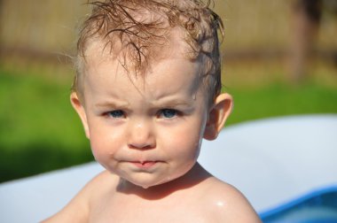 Wet little boy with anger on his face clipart