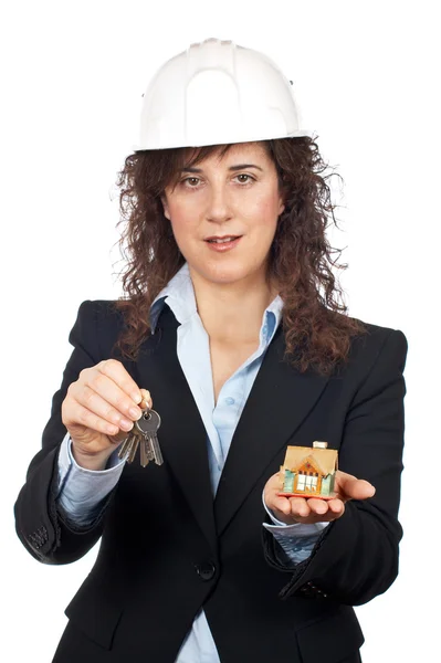 Женщина-архитектор держит ключи и дом — стоковое фото