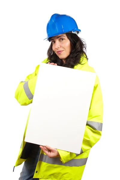Vrouwelijke bouwvakker toont een lege banner — Stockfoto