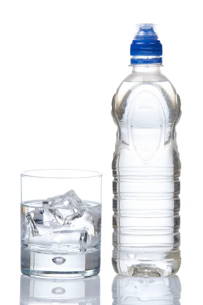 Botella y vaso de agua mineral con gotitas — Foto de Stock