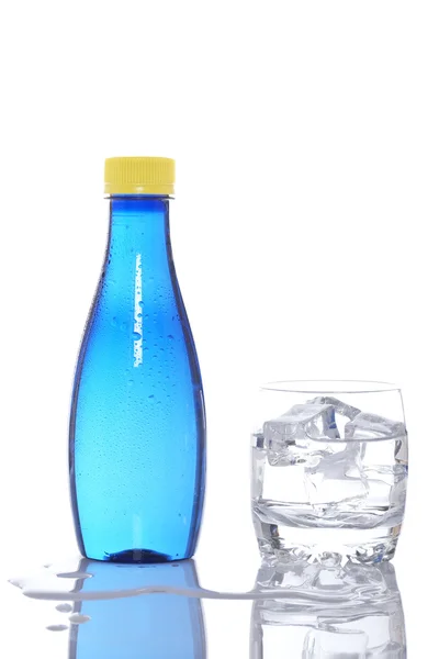 Láhve a sklo minerální vody kapky — Stock fotografie