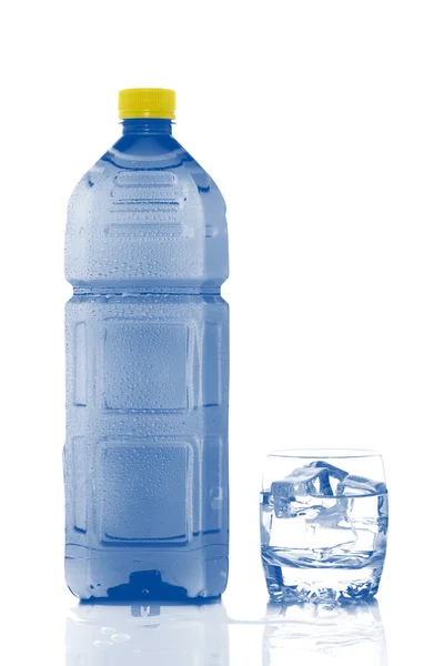 Garrafa e vidro de água mineral com gotículas — Fotografia de Stock
