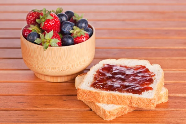 Two toast with jam, blueberries and strawberries — Stock Photo, Image