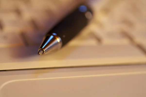 Macro de un bolígrafo con el foco en la punta de un teclado — Foto de Stock