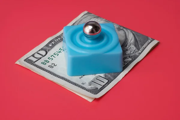 Aço de mármore sobre plataforma azul e nota de dez dólares, em um fundo vermelho — Fotografia de Stock