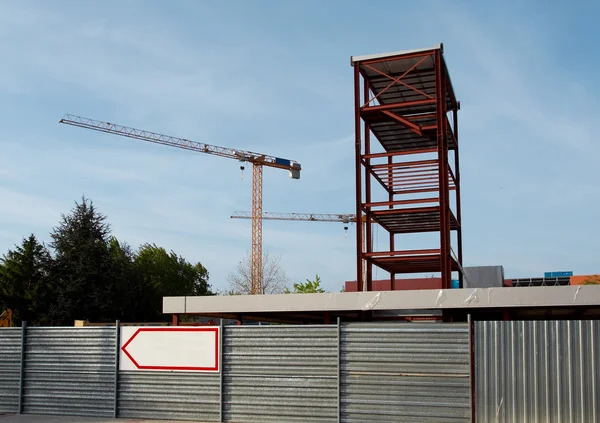 Estrutura de aço e guindaste de construção conjunto contra um céu azul — Fotografia de Stock