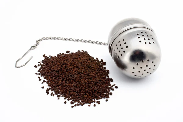 Thé et boule de thé en acier inoxydable sur fond blanc — Photo