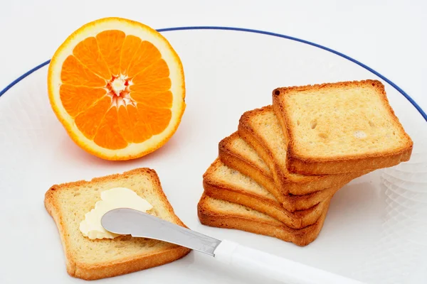 Tostadas con mantequilla y media naranja — Foto de Stock
