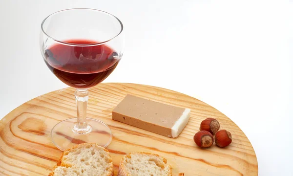 Pate, bread, glass of red wine, hazelnuts on wood plate — Stock Photo, Image