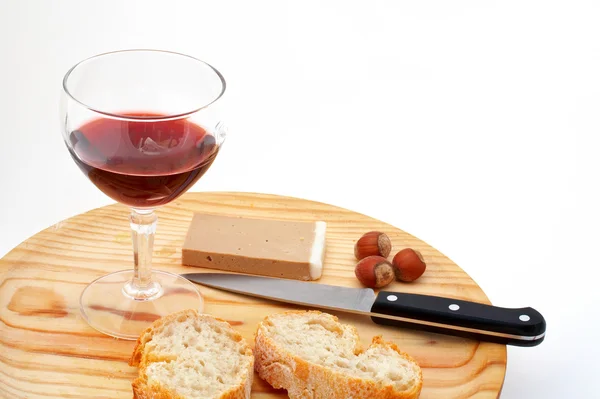 Pate, brood, glas rode wijn, hazelnoten en mes op hout plat — Stockfoto
