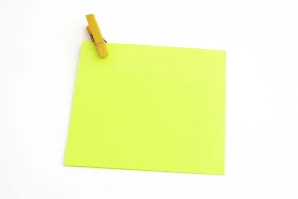 Isolated green paper with yellow clamp — Stock Photo, Image