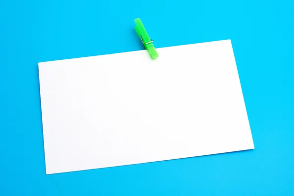 Isolated white paper with green clamp — Stock Photo, Image