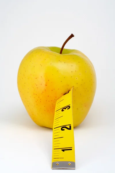 Яблоко с рулеткой — стоковое фото