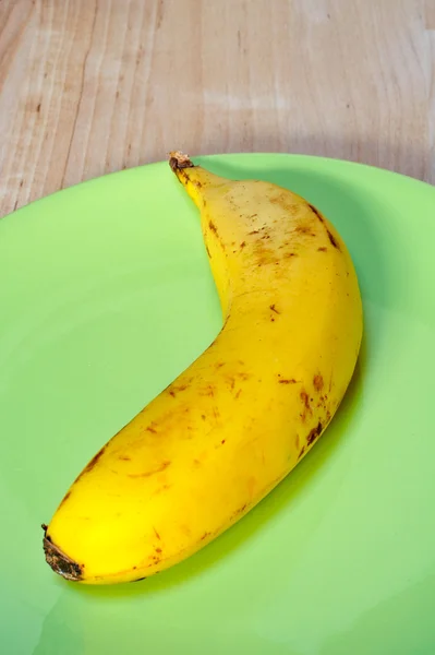 Банан на зеленой тарелке — стоковое фото