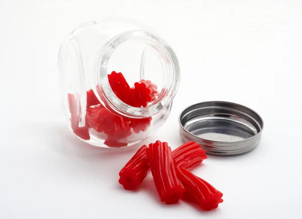 Bitar av röd lakrits på glasburk — Stockfoto