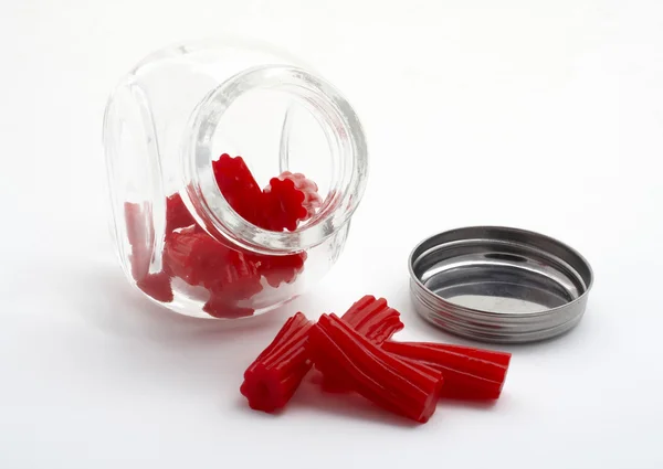 Bitar av röd lakrits på glasburk — Stockfoto